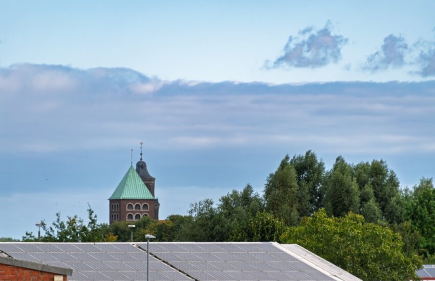 Church tower with green roof amongst trees